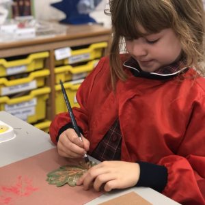 child painting onto a leaf
