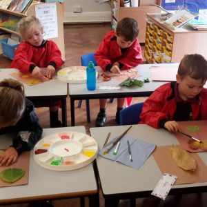 students painting onto leaves